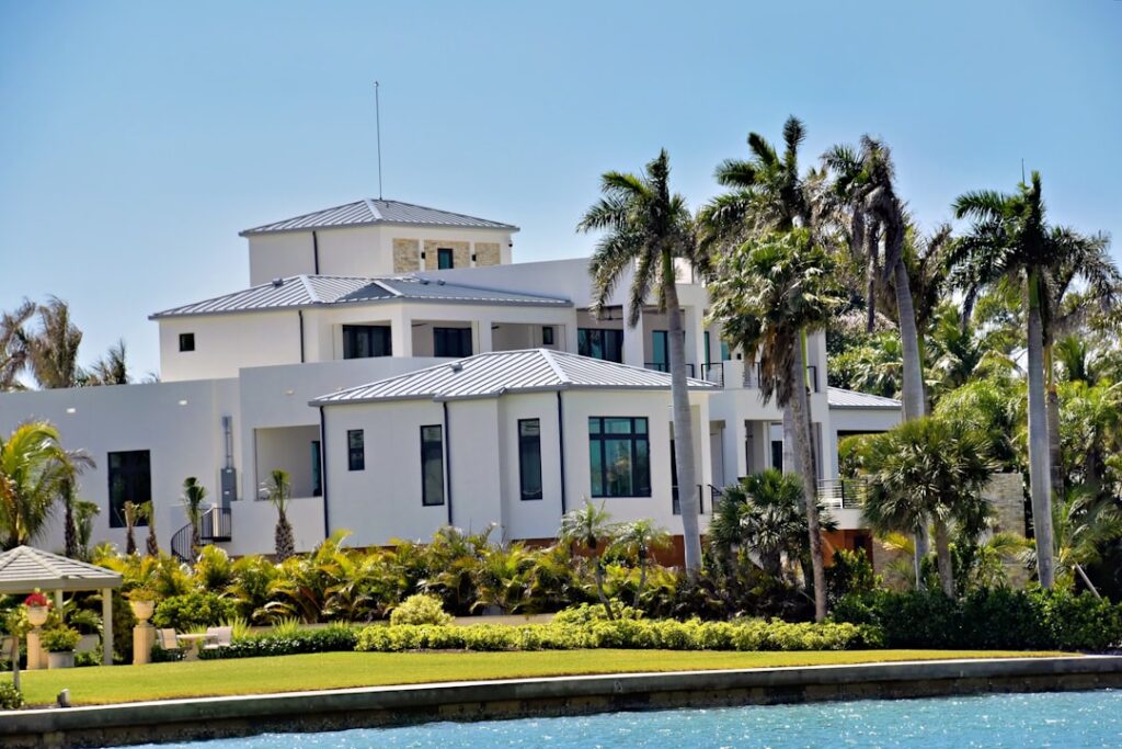 Well-maintained Gulf Coast home stands securely next to a dock where a charter fishing boat is moored on a bright, sunny d...